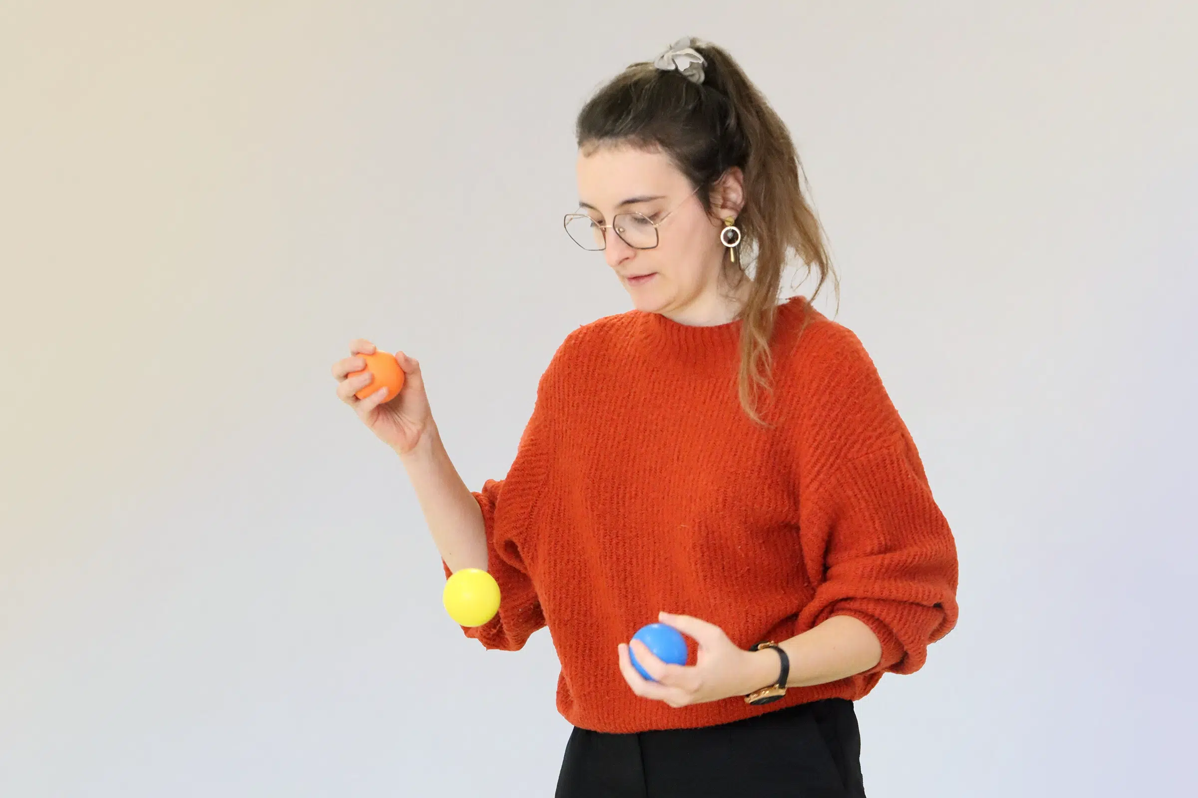 Personne en pleine concentration jonglant avec trois balles colorées pendant un exercice de Brain Ball®, illustrant l’état de flow et la concentration optimale.