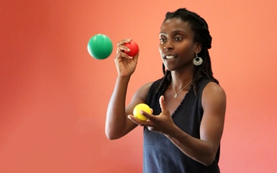 Pour illustrer notre page "Brain Ball Avis" nous avons choisi une photo d'une jeune femme, concentrée et souriante, pratiquant le Brain Ball avec 3 balles