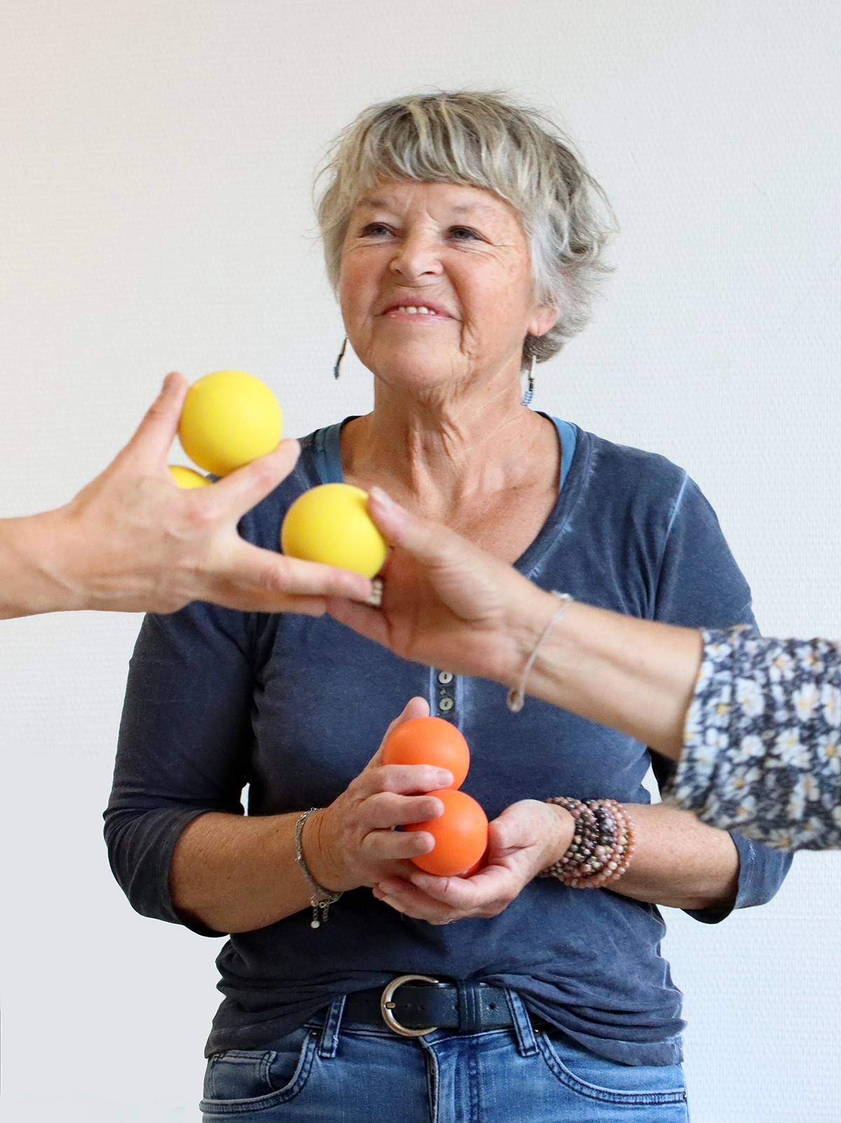 Une senior pratiquant le Brain Ball en tant que Sport-Santé. Elle tient des balles et sourit