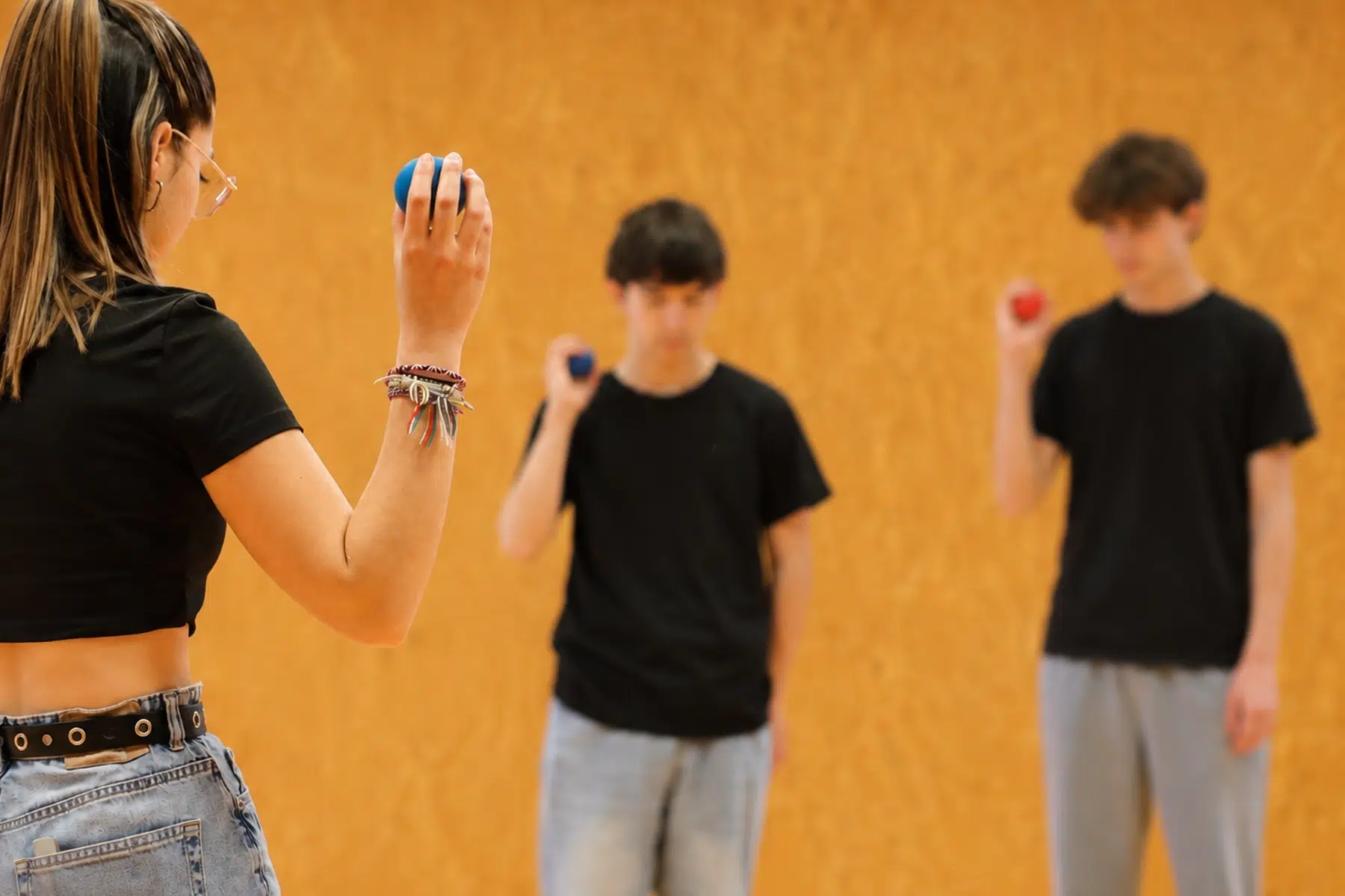 Distance entre participants tenant une balle, illustrant la proxémie en activité adaptée au TSA